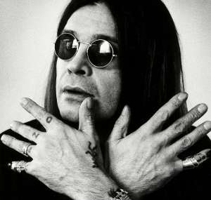 Ozzy Osbourne showing his rings and hand tattoos
