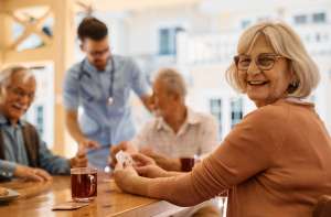 Elderly people socializing and talking together at a community center.