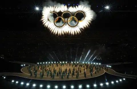 The opening ceremony at the Winter Olympics in Milan. The Olympic rings are above the athletes.